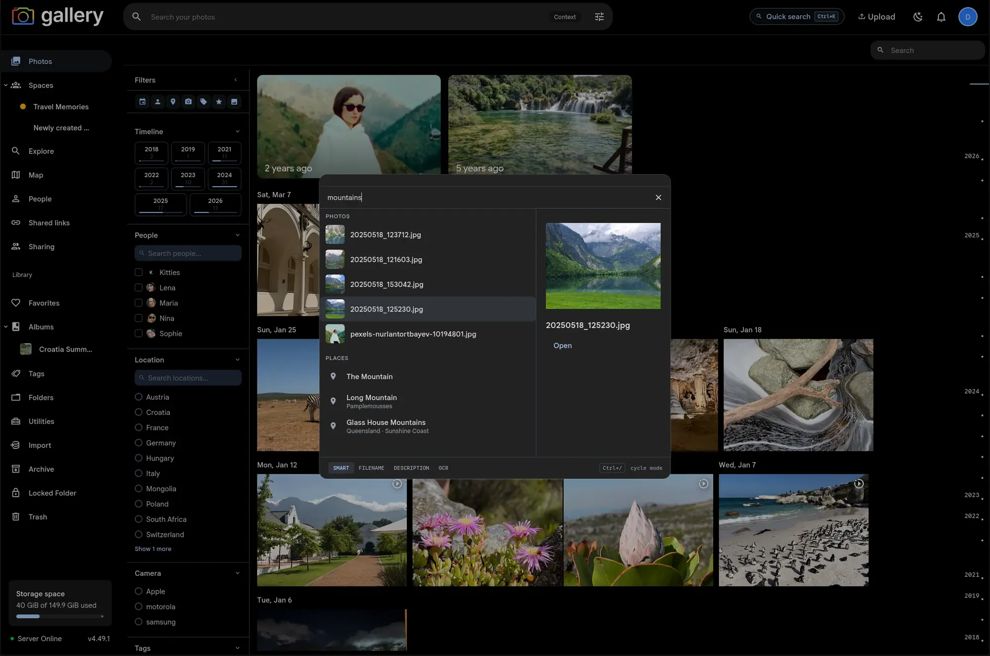 Gallery's photo timeline with the Cmd+K search palette open over it, showing 'mountains' typed into the input, photo and place result sections, and a preview pane on the right with a mountain lake thumbnail